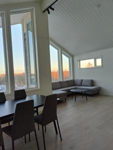 布伦讷于松Torghatten bnb的大型客房设有桌椅和窗户。