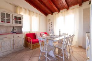 圣特奥多罗撒丁岛夏日丽卡普拉提公寓的厨房以及带桌椅的用餐室。