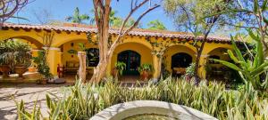 阿拉莫斯La Quinta en Alamos的花园中一座黄色房子,设有喷泉