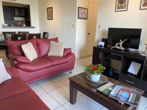 圣萨尔瓦多Luxury Modrn Apartment, w/amazing view, 3BR,Escalon,Exclus,Secur的客厅配有红色沙发和茶几