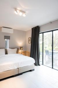 奥斯特坎普Loweide Lodges & Holiday Homes near Bruges的一间卧室设有一张床和一个大窗户