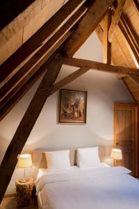 奥斯特坎普Loweide Lodges & Holiday Homes near Bruges的阁楼卧室配有白色床