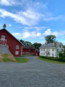 特隆赫姆Storsand Gård的道路上的一个红谷仓和白色的建筑