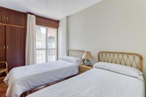 桑亨霍Apartamentos Granxola的一间卧室设有两张床和窗户。