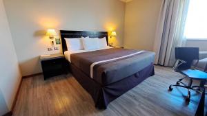 奇廉奇廉迭戈阿尔马格罗酒店的酒店客房带一张大床和一把椅子
