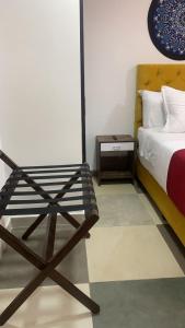 波哥大Hotel Bogota Resort的一间卧室配有一张床和一张木椅
