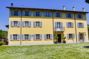 圣斯泰法诺贝尔博Vigna Dell'Acqua的黄色的房子,有蓝色的窗户和院子