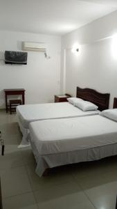 福尔摩沙HOTEL FERMOZA的白色墙壁客房的两张床