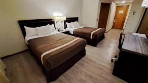 库里科库里科阿尔马格罗迪亚哥酒店的酒店客房设有两张床和一张桌子。
