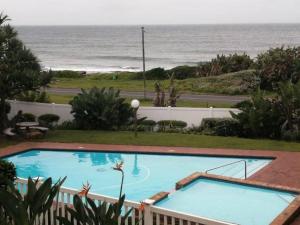 乌旺戈海滩Seaview Beachfront Holiday Apartment - 164 Laguna La Crete的一座背景海洋的游泳池