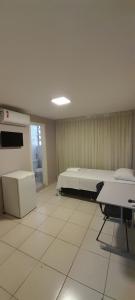 巴西利亚Pousada Kit Residence的一间设有床铺和桌子的房间