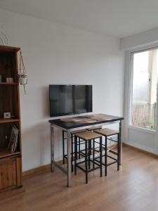 蒙彼利埃Appartement Circé - Montpellier Nord-Hopitaux-Facultés的一张桌子、椅子和电视