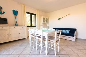 圣特奥多罗撒丁岛夏日丽卡普拉提公寓的一间配备有白色桌椅的用餐室