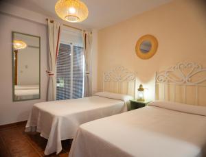 萨各夫雷纳圣胡安旅馆的一间卧室设有两张床和窗户。