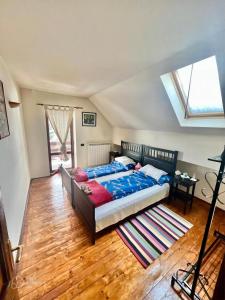 布什泰尼Blue Sky的一间卧室配有一张床,铺有木地板
