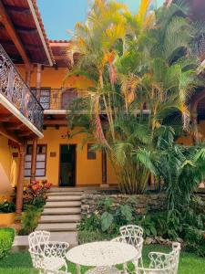 科米坦德多明格斯Hotel Jardín de Tereza的房屋前设有带2张桌子和椅子的庭院。
