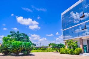 达累斯萨拉姆Muhako Hotel的一座棕榈树掩映的玻璃建筑