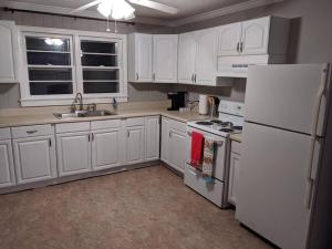甘特斯维尔1. Lakeview home in Beautiful Guntersville的厨房配有白色橱柜和白色冰箱。