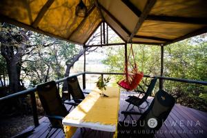 卡蒂马穆利洛Kubu & Kwena Lodge的门廊上的桌椅和秋千