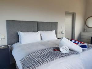 阿古拉斯Southern most tip of Africa apartment with sea views的一张大白色的床,上面有毯子