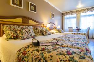 格拉玛多西拉角酒店的一间卧室配有两张床,书上写着