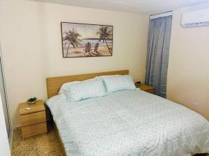 Punta SantiagoOcean Breeze的卧室配有一张床,墙上挂着一幅画