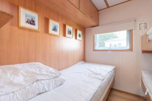 米茨兰Heidehut的一间小卧室,配有床和窗户