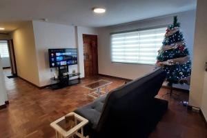 拉巴斯Acogedor apartamento cerca del teleférico amarillo的客厅配有圣诞树和沙发