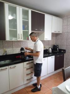 本图贡萨尔维斯Pousada paraíso的站在厨房里,拿着搅拌机的人