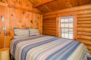 WestmoreMountain Lake Cottages的小木屋内一间卧室,配有一张床