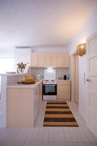 米克诺斯城Hidden Serenity的厨房配有白色橱柜和炉灶烤箱。