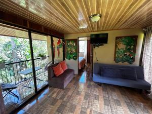TamborCabaña en Alajuela en lugar tranquilo y con mucha naturaleza.的客房设有一个带沙发和电视的阳台。