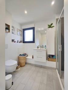 Savigniesmaison nature spéciale JO 2024的白色的浴室设有卫生间和水槽。