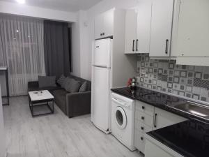 伊斯坦布尔*Новая квартира 1+1 Mecidiyeköy的厨房以及带沙发和冰箱的客厅。