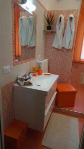 泰尔梅维利亚托雷海上阳台公寓的浴室配有盥洗盆、镜子和毛巾