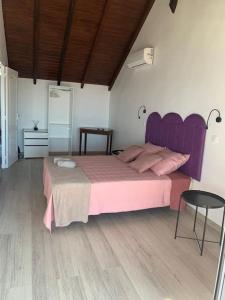 波尔兰特Duplex Rose Porcelaine - Vue Mer- Malendure的卧室配有粉红色的床和桌子