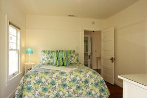 太平洋丛林3118 Yellow House Main home的一间卧室配有一张带花卉床罩的床