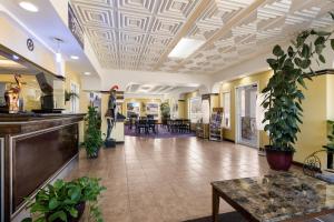 阿尔派恩Americas Best Value Inn Alpine的医院的大厅,里面有植物和桌子