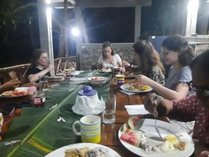 库鲁内格勒THE HIDEOUT KURUNEGALA的一群坐在桌子旁吃食物的人