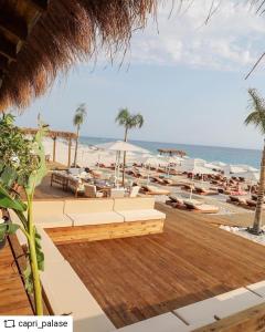 LlogaraHeaven Residence - Green Coast Resort, Palasë的享有带椅子和遮阳伞的海滩美景