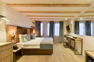 日内瓦Hôtel Rousseau Plus的配有一张床和一张书桌的酒店客房
