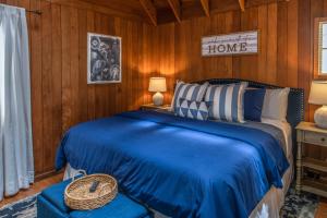 卡梅尔3796 The Madden Suite apts的一间设有蓝色床的卧室,位于带木墙的房间