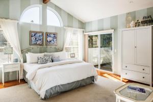 蒙特雷3485 Avalon by the Sea home的一间卧室设有一张大床和两个窗户。