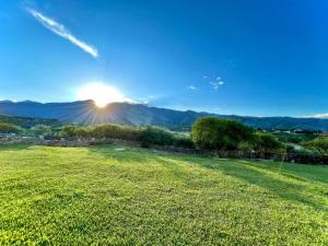 塔里哈Casa de Campo La Montaña的一片有太阳背景的草场