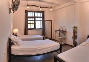 弗洛勒斯Hostal Don Cenobio的客房设有两张床和窗户。