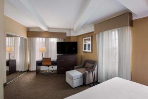 锡拉丘兹Best Western Syracuse Downtown Hotel and Suites的酒店客房配有一张床、一张书桌和一台电视。