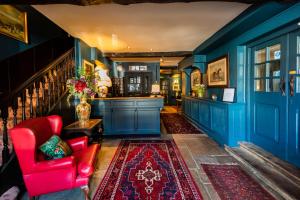 奥克姆The George Inn的客厅设有蓝色的墙壁和红色的椅子
