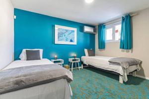 棕榈滩Ojanea Home的蓝色墙壁客房的两张床
