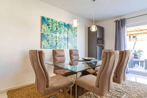 棕榈滩Ojanea Home的一间设有玻璃桌和椅子的用餐室