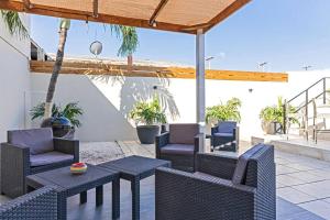 棕榈滩Ojanea Home的庭院设有藤椅和桌子。